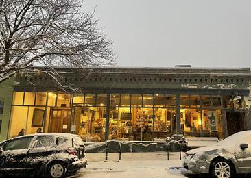 Potager’s storefront on a snowy evening with warm light in the windows